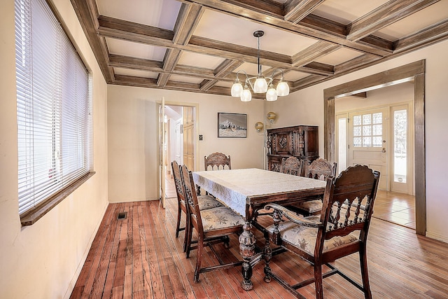 dining room with beam ceiling, wood-type flooring, a chandelier, and visible vents