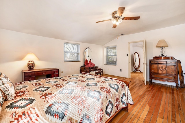 bedroom with lofted ceiling, a ceiling fan, and wood-type flooring