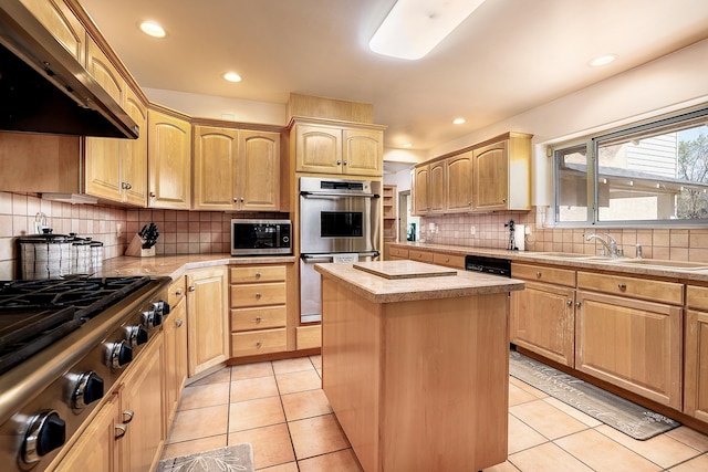 kitchen featuring light countertops, appliances with stainless steel finishes, light brown cabinets, and exhaust hood