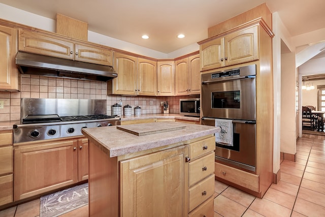 kitchen with light brown cabinets, under cabinet range hood, stainless steel appliances, and light tile patterned floors