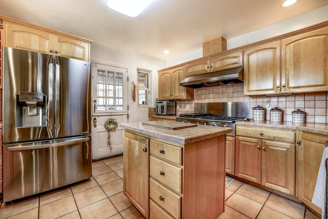 kitchen with appliances with stainless steel finishes, a center island, under cabinet range hood, and light tile patterned floors