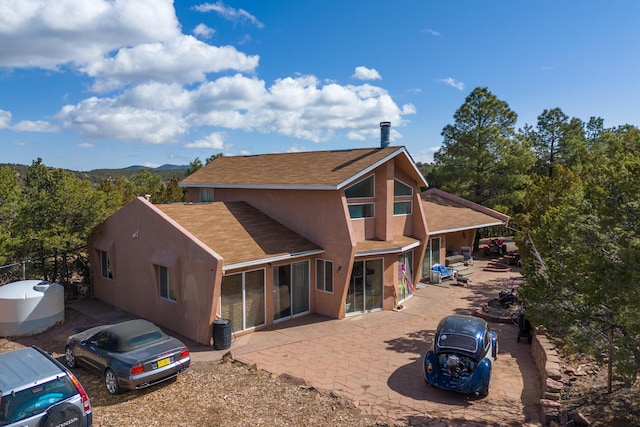 32 Puntilla Dr Unit B, Tijeras, NM 87059 - rear view of property with a patio area, roof with shingles, and stucco siding