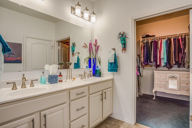 full bathroom with double vanity, baseboards, and a sink