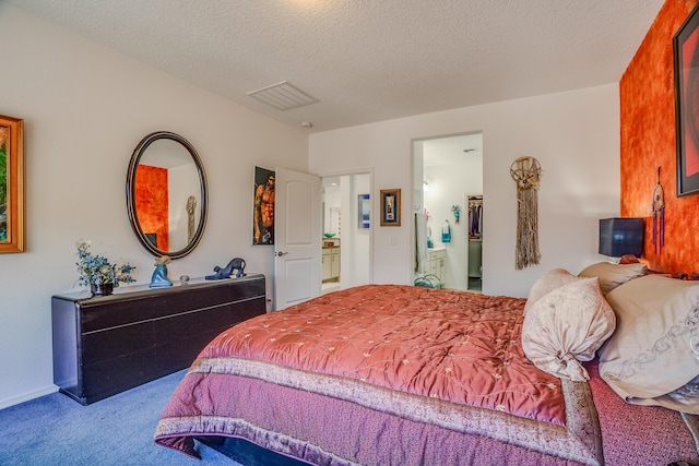 bedroom featuring a textured ceiling, visible vents, ensuite bath, and carpet