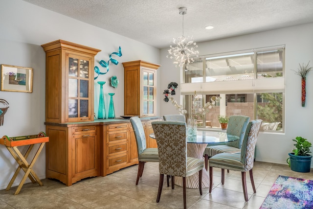 dining area featuring light tile patterned floors, baseboards, an inviting chandelier, and a textured ceiling