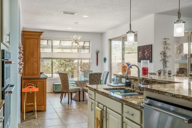 kitchen with dishwasher, a sink, visible vents, and hanging light fixtures