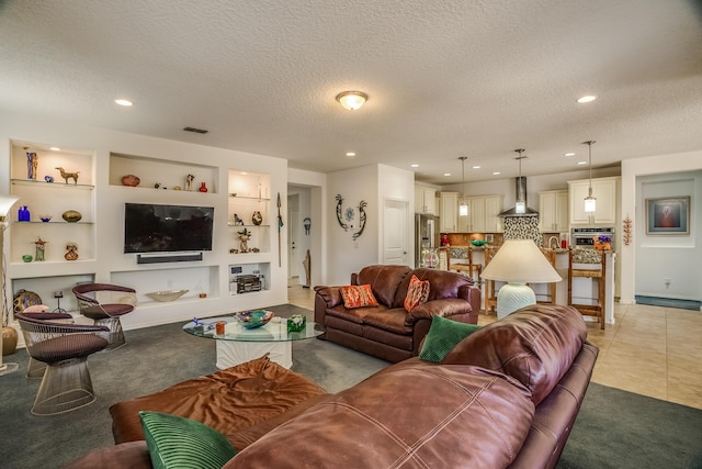 living area with visible vents, light carpet, and a textured ceiling