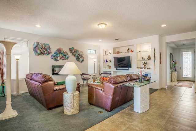 tiled living area featuring visible vents, built in shelves, recessed lighting, and a textured ceiling