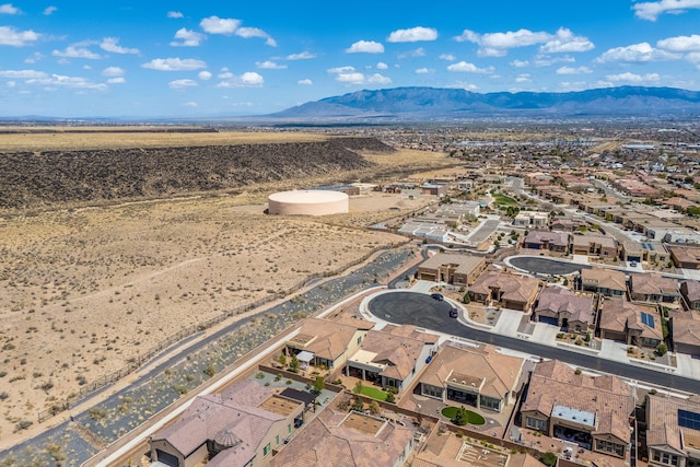 aerial view featuring a mountain view, view of desert, and a residential view