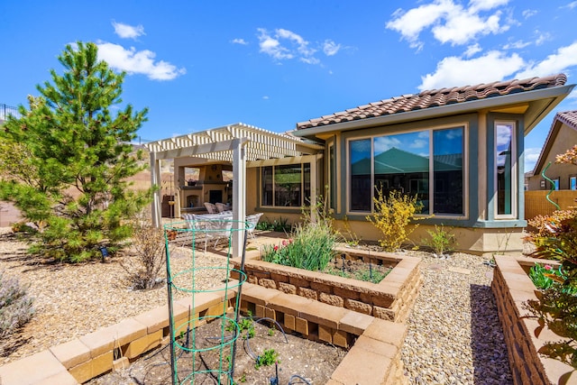 back of property featuring a pergola, a patio area, stucco siding, and a tile roof