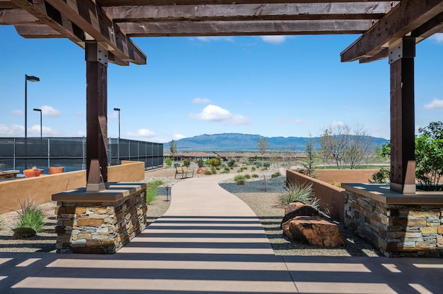 view of patio / terrace featuring a mountain view, fence, and a pergola