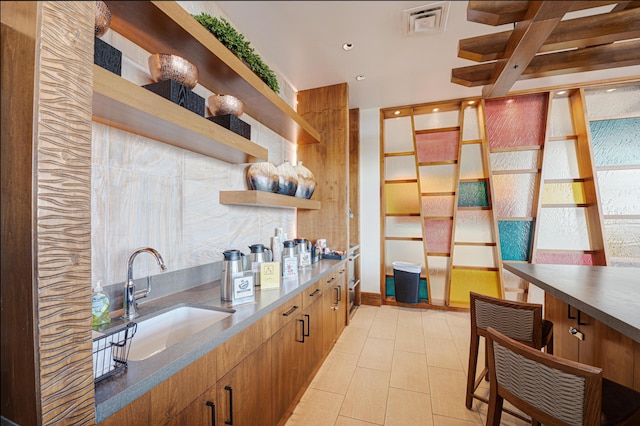 kitchen featuring light tile patterned floors, modern cabinets, open shelves, visible vents, and a sink