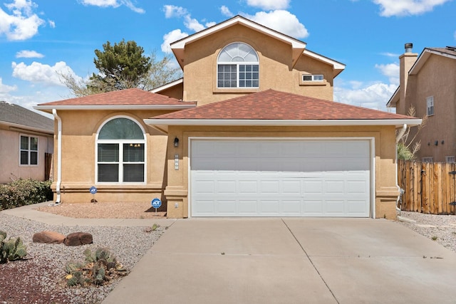 view of front of home featuring stucco siding, fence, an attached garage, a shingled roof, and concrete driveway