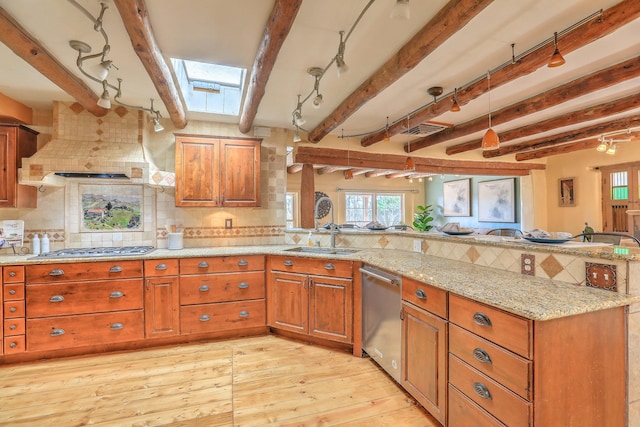 78 Quirks Ln, Corrales, NM 87048 - kitchen with appliances with stainless steel finishes, a sink, a peninsula, brown cabinets, and a skylight