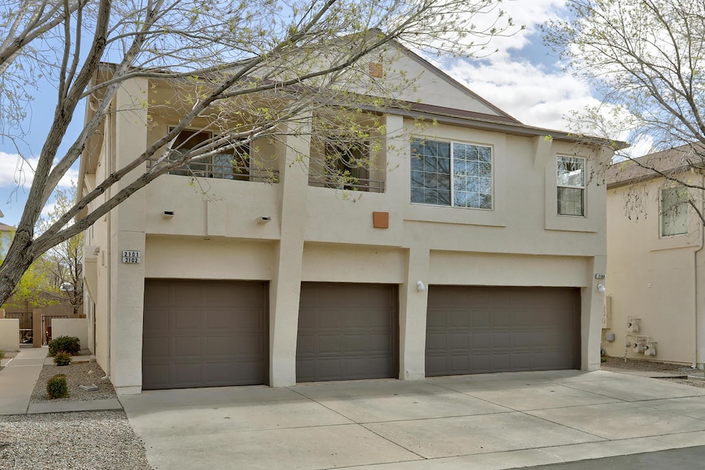 exterior space with an attached garage, stucco siding, and concrete driveway