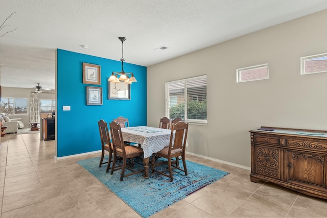 dining area featuring light tile patterned flooring, a textured ceiling, a ceiling fan, baseboards, and visible vents