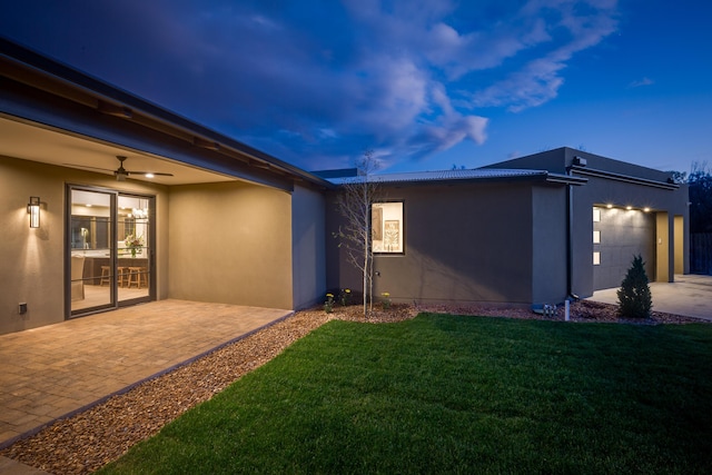 1016 Guadalupe Villa NW, Albuquerque, NM 87114 - back of property with ceiling fan, stucco siding, a lawn, a patio area, and a garage