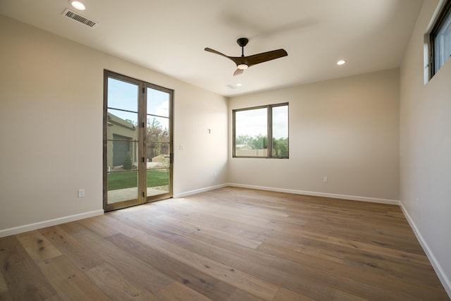 1016 Guadalupe Villa NW, Albuquerque, NM 87114 - empty room with visible vents, wood-type flooring, a ceiling fan, and plenty of natural light