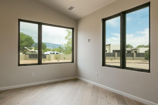 1016 Guadalupe Villa NW, Albuquerque, NM 87114 - empty room with visible vents, lofted ceiling, light wood finished floors, a mountain view, and baseboards