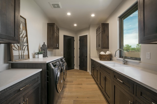 1016 Guadalupe Villa NW, Albuquerque, NM 87114 - clothes washing area with independent washer and dryer, light wood-style flooring, visible vents, a sink, and cabinet space