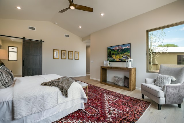 1016 Guadalupe Villa NW, Albuquerque, NM 87114 - bedroom with visible vents, light wood finished floors, a barn door, and lofted ceiling