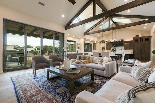 1016 Guadalupe Villa NW, Albuquerque, NM 87114 - living room with an inviting chandelier, high vaulted ceiling, beamed ceiling, visible vents, and light wood finished floors