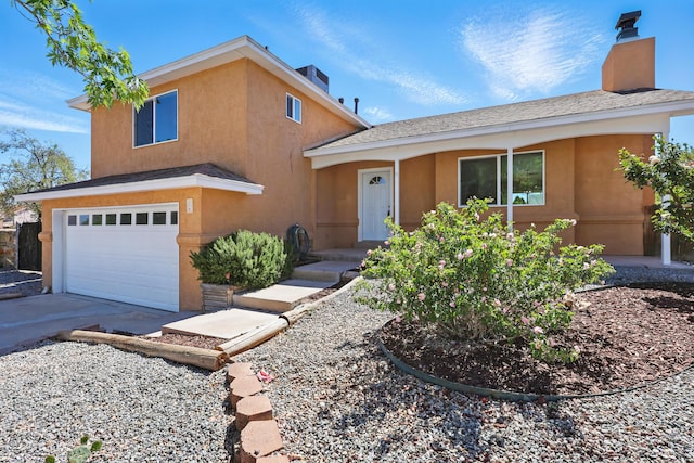 16 Apache Plume Rd, Los Lunas, NM 87031 - view of front of property featuring stucco siding, a garage, a chimney, and concrete driveway