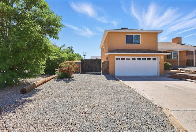 16 Apache Plume Rd, Los Lunas, NM 87031 - view of front of house with stucco siding, a garage, concrete driveway, and a gate