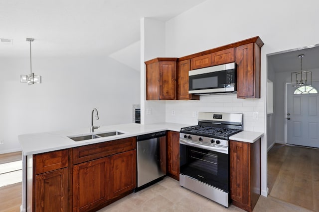 16 Apache Plume Rd, Los Lunas, NM 87031 - kitchen with stainless steel appliances, a peninsula, tasteful backsplash, hanging light fixtures, and lofted ceiling