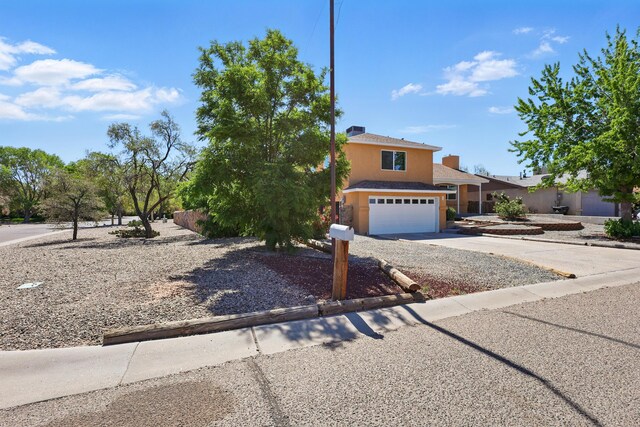 16 Apache Plume Rd, Los Lunas, NM 87031 - view of front facade with an attached garage, concrete driveway, and stucco siding