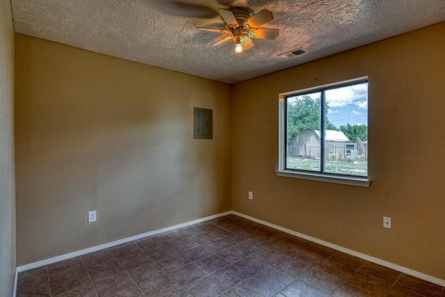 tiled empty room featuring a ceiling fan, a textured ceiling, baseboards, and electric panel