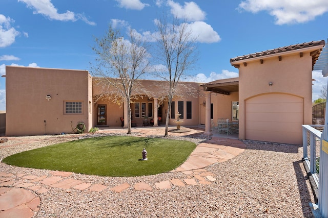 3605 Greystone Ridge Dr SE, Rio Rancho, NM 87124 - back of house with stucco siding, driveway, an attached garage, a lawn, and a patio area