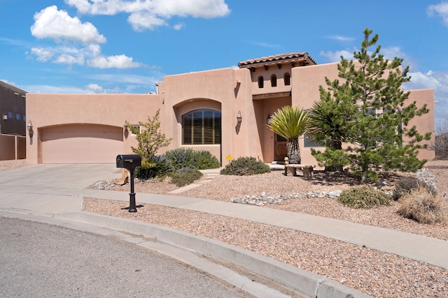 3605 Greystone Ridge Dr SE, Rio Rancho, NM 87124 - pueblo-style home with stucco siding, concrete driveway, and a garage