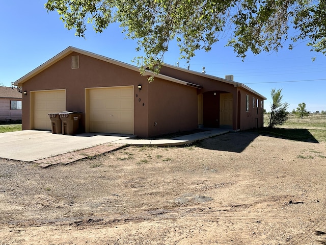 504 Maple Ave, Moriarty, NM 87035 - view of front of property with stucco siding, a garage, and concrete driveway