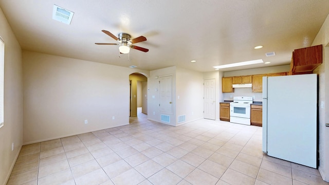 504 Maple Ave, Moriarty, NM 87035 - kitchen featuring white appliances, a ceiling fan, arched walkways, under cabinet range hood, and recessed lighting