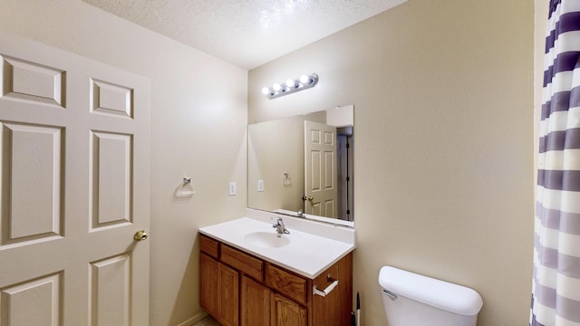 504 Maple Ave, Moriarty, NM 87035 - full bathroom featuring toilet, vanity, a textured ceiling, and a shower with shower curtain