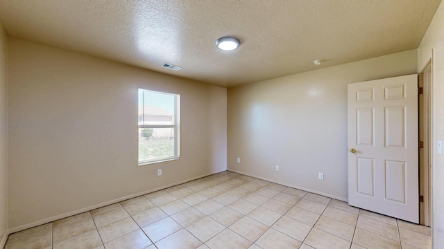 504 Maple Ave, Moriarty, NM 87035 - spare room with a textured ceiling, light tile patterned flooring, baseboards, and a smoke detector
