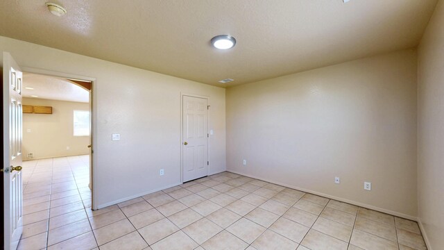 504 Maple Ave, Moriarty, NM 87035 - empty room with arched walkways, light tile patterned floors, baseboards, and a smoke detector
