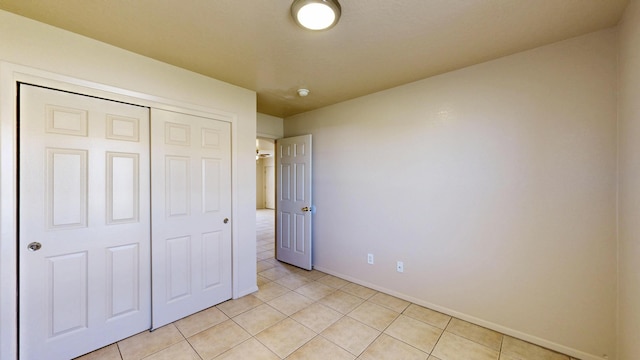 504 Maple Ave, Moriarty, NM 87035 - unfurnished bedroom with light tile patterned flooring, baseboards, and a closet