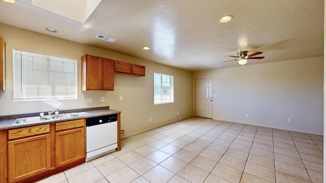 504 Maple Ave, Moriarty, NM 87035 - kitchen with dishwasher, a sink, brown cabinets, ceiling fan, and a textured ceiling