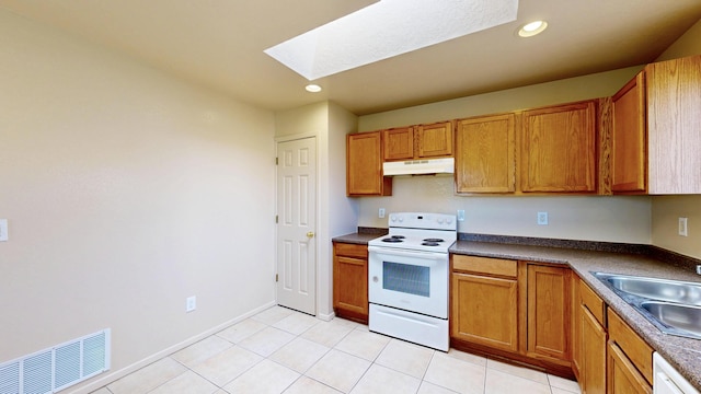 504 Maple Ave, Moriarty, NM 87035 - kitchen with white appliances, under cabinet range hood, a skylight, a sink, and brown cabinets