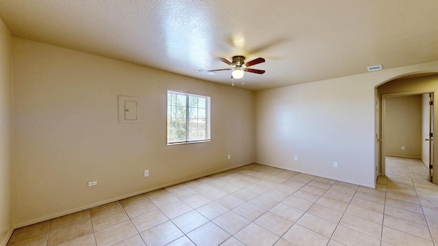 504 Maple Ave, Moriarty, NM 87035 - empty room featuring arched walkways, ceiling fan, light tile patterned flooring, and baseboards