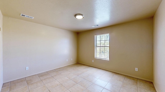 504 Maple Ave, Moriarty, NM 87035 - empty room with light tile patterned flooring, baseboards, and a textured ceiling
