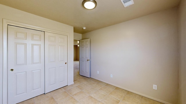 504 Maple Ave, Moriarty, NM 87035 - unfurnished bedroom featuring baseboards, a closet, and light tile patterned floors