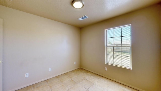 504 Maple Ave, Moriarty, NM 87035 - unfurnished room featuring baseboards, light tile patterned floors, and a textured ceiling