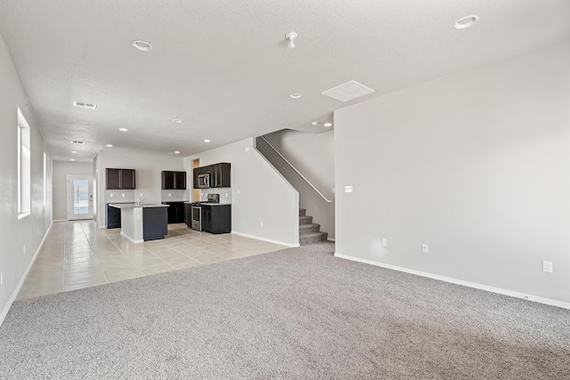 6814 Atherstone Ln NW, Albuquerque, NM 87114 - unfurnished living room with light carpet, baseboards, recessed lighting, stairs, and light tile patterned floors