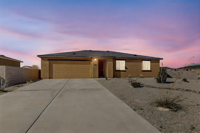 2402 Calle Del Los Claveles, Belen, NM 87002 - view of front facade featuring an attached garage, fence, driveway, and stucco siding