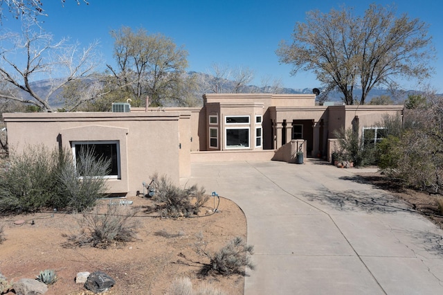 122 Martha Ct, Corrales, NM 87048 - view of front facade with a patio, driveway, stucco siding, and a mountain view