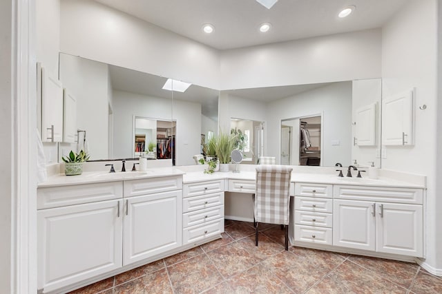 122 Martha Ct, Corrales, NM 87048 - bathroom featuring a skylight, two vanities, a sink, and a spacious closet