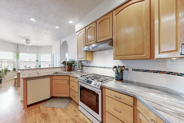 122 Martha Ct, Corrales, NM 87048 - kitchen with light wood-style floors, gas range, under cabinet range hood, white dishwasher, and light brown cabinets